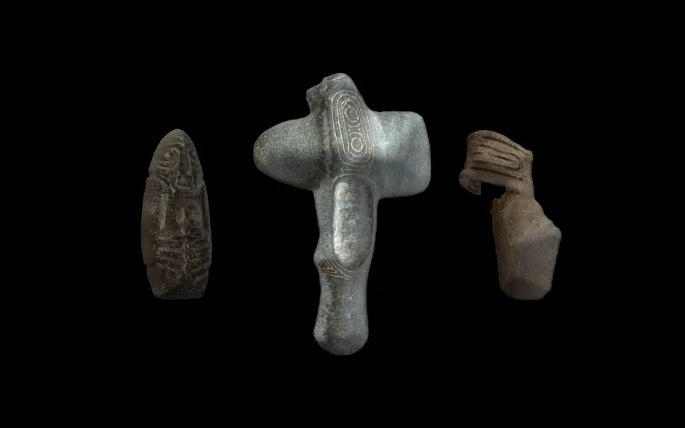 Three Taíno objects shown as 3D models on black: a winged stone in front, a stone figure and a clay fragment set back in shadow